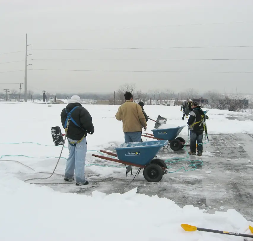 Crew Removing snow On Flat Roof