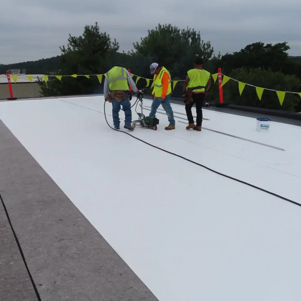 Vanguard Roofer applying roof coating to a flat roof in New Jersey